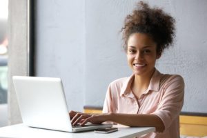 Portrait of a young woman working on laptop in office